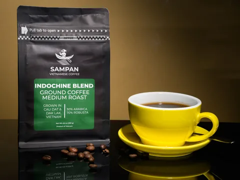 Sampan Indochine Blend Vietnamese coffee bag beside a yellow cup of freshly brew